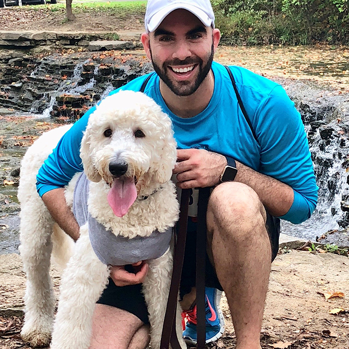 Dr. Fadi Tayim Kneeling with his goldendoodle Odie
