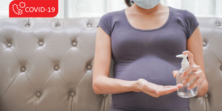 Pregnant woman in PPE and with hand sanitizer